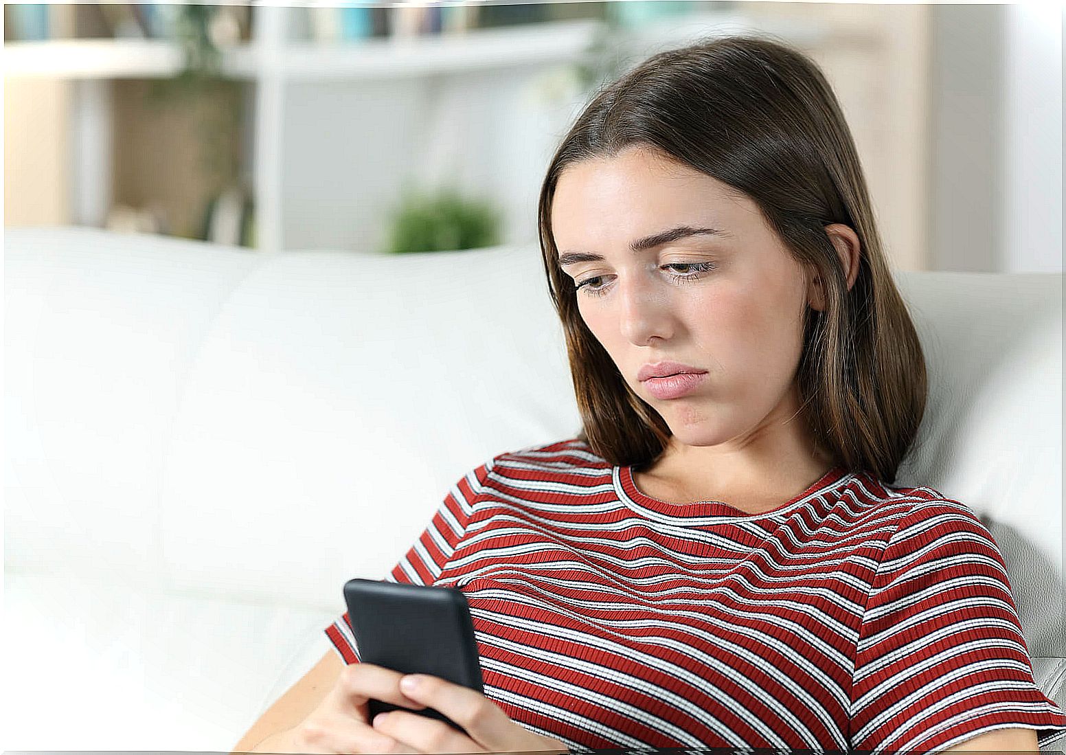 Woman checks mobile without moving.