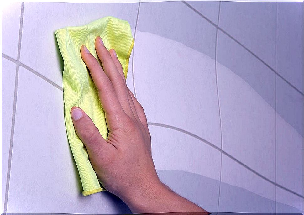 Hand wiping the wall with a rag