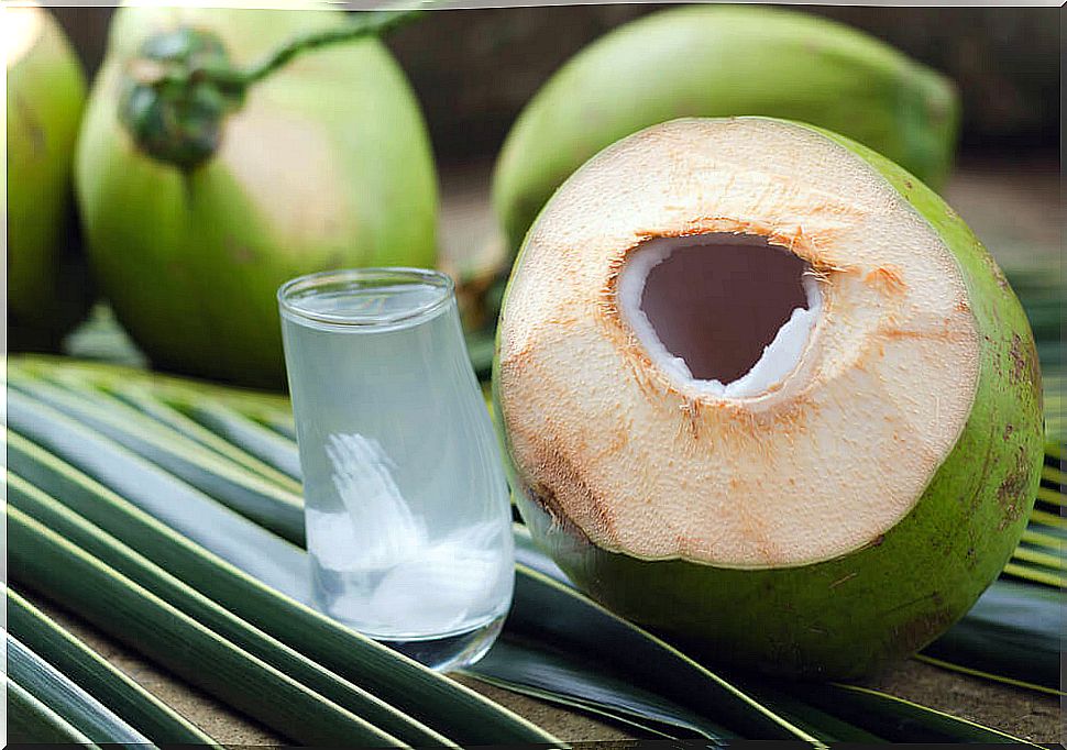 Glass of green coconut water with lemon.